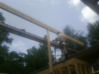 Carpenter setting a ridge beam over a new addition frame — Ice Dam Removal by Roofing Brothers in Hoagland