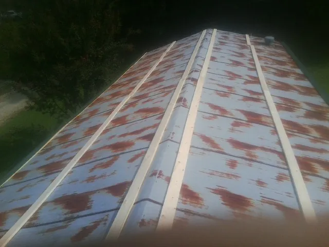 Rusted metal roof panels with new wood purlins before replacement — Storm Damage Roof Repair in Hoagland by Roofing Brothers