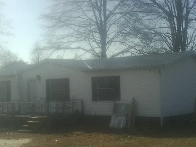 New metal roof on a white painted brick home on a foggy morning in Hoagland
