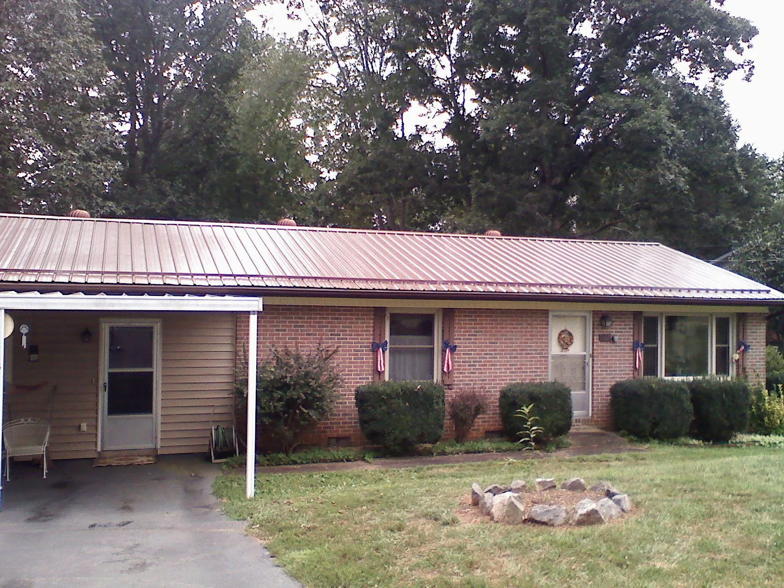 Bronze metal roof and carport on a brick ranch home — Roof Repair work by our crew in Hoagland